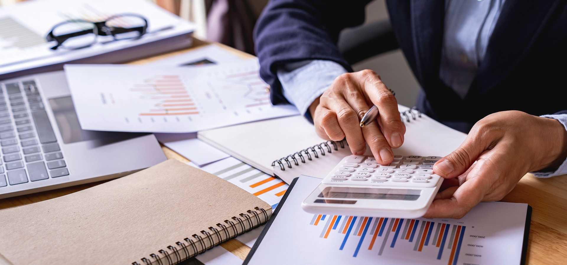 An accountant working a desk covered in client sensitive paperwork which can be destroyed by papermountains secure shredding services