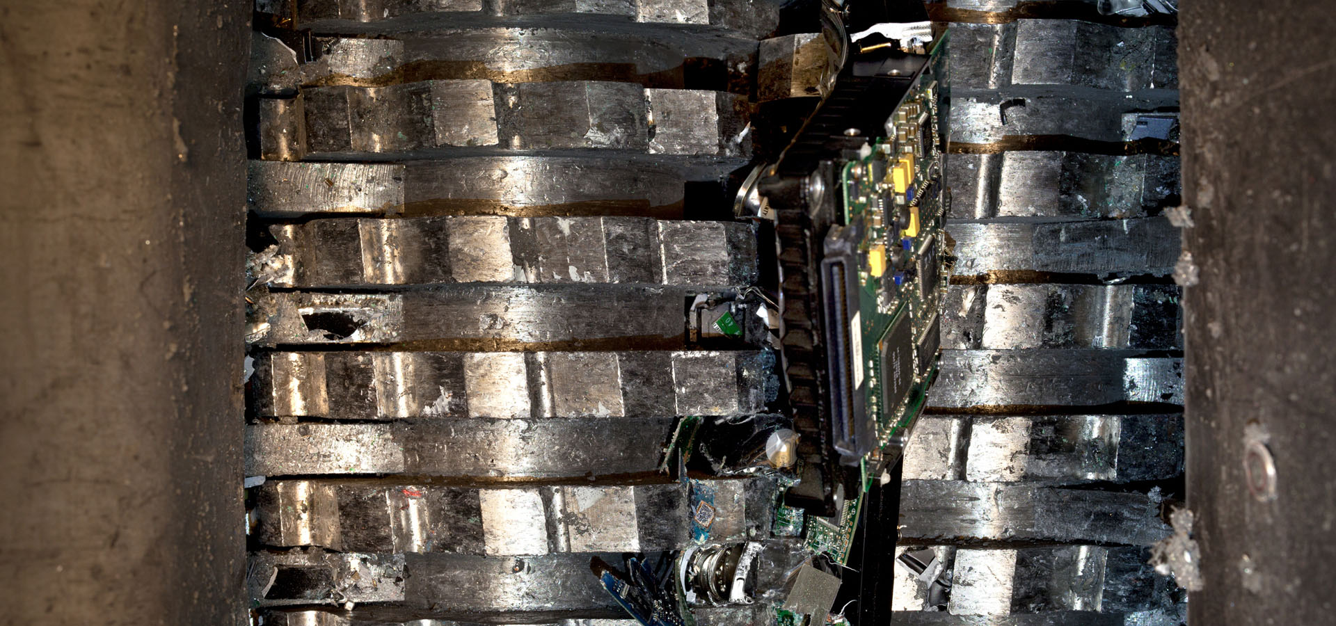 Hard drive being shredded in between the cutting heads of the shredder