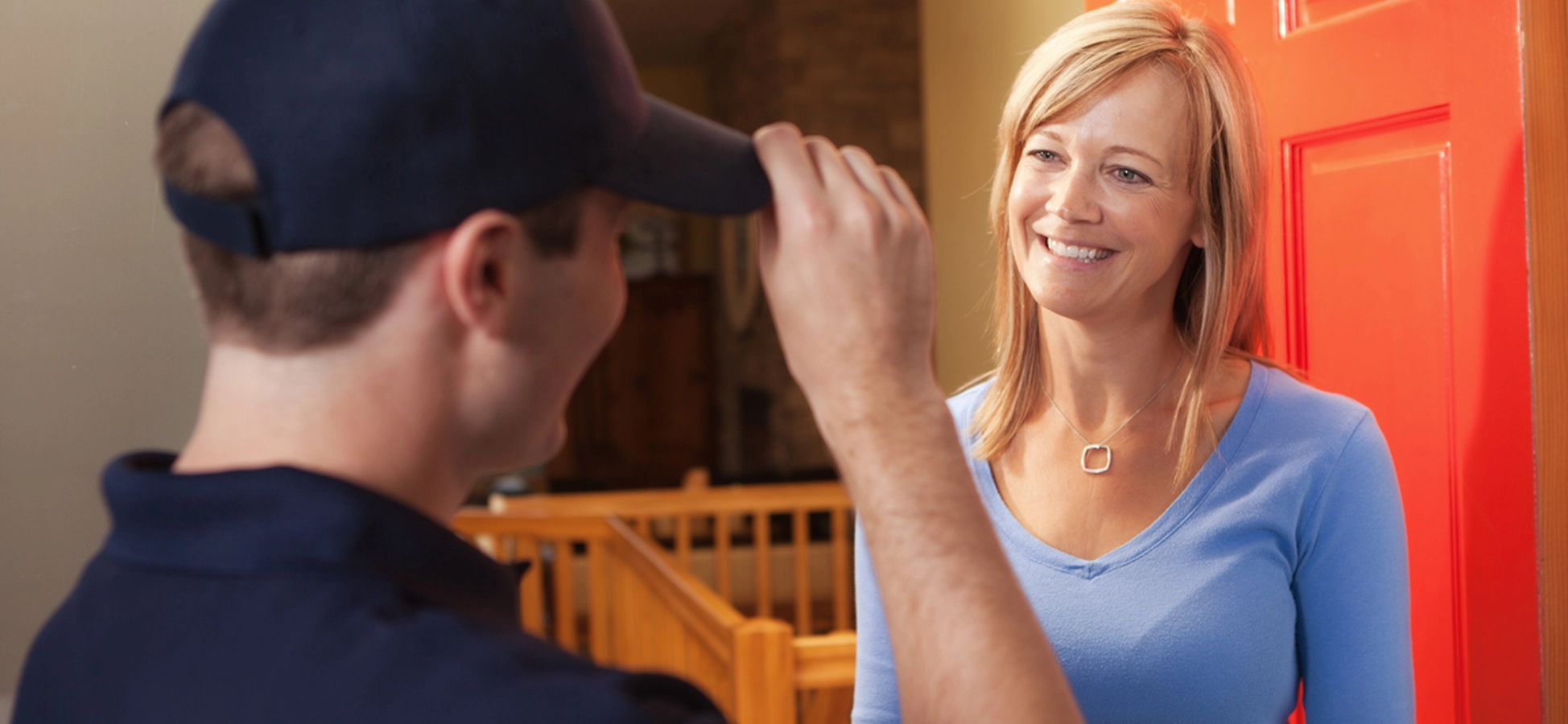 A PaperMountains Driver in uniform greeting a home shredding service customer at her door as he collects her waste paper for confidential destruction by shredding.