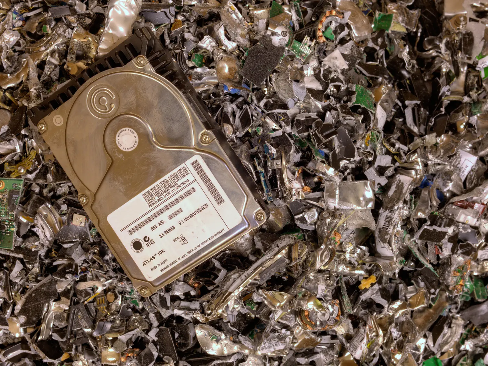 hard drive in a shredder going between the cutters