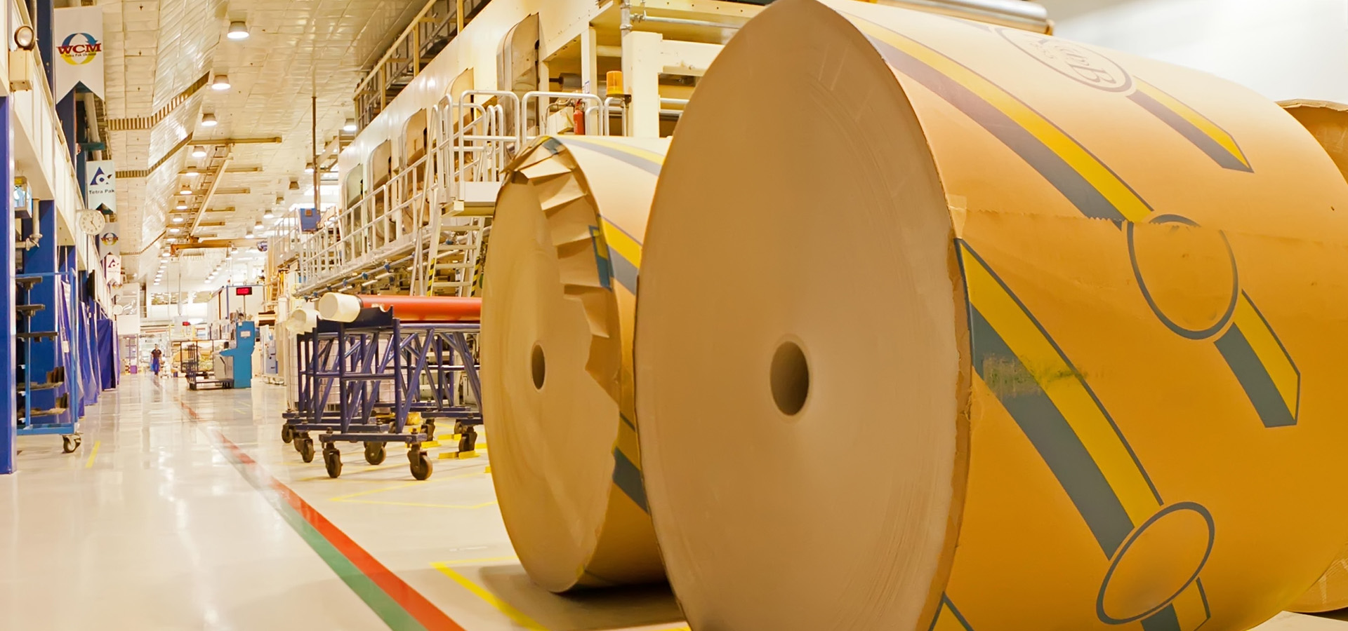 two giant rolls of recycled paper standing in a factory