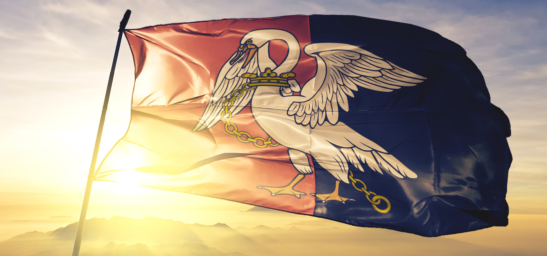 The Flag Of Buckinghamshire Flying In Front of A Bright Sunrise