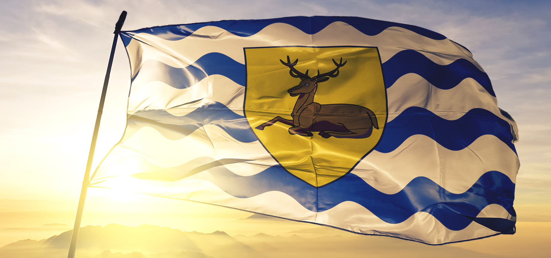 Hetfordshire Flag Flying On A Pole With A Bright Sunrise Behind It