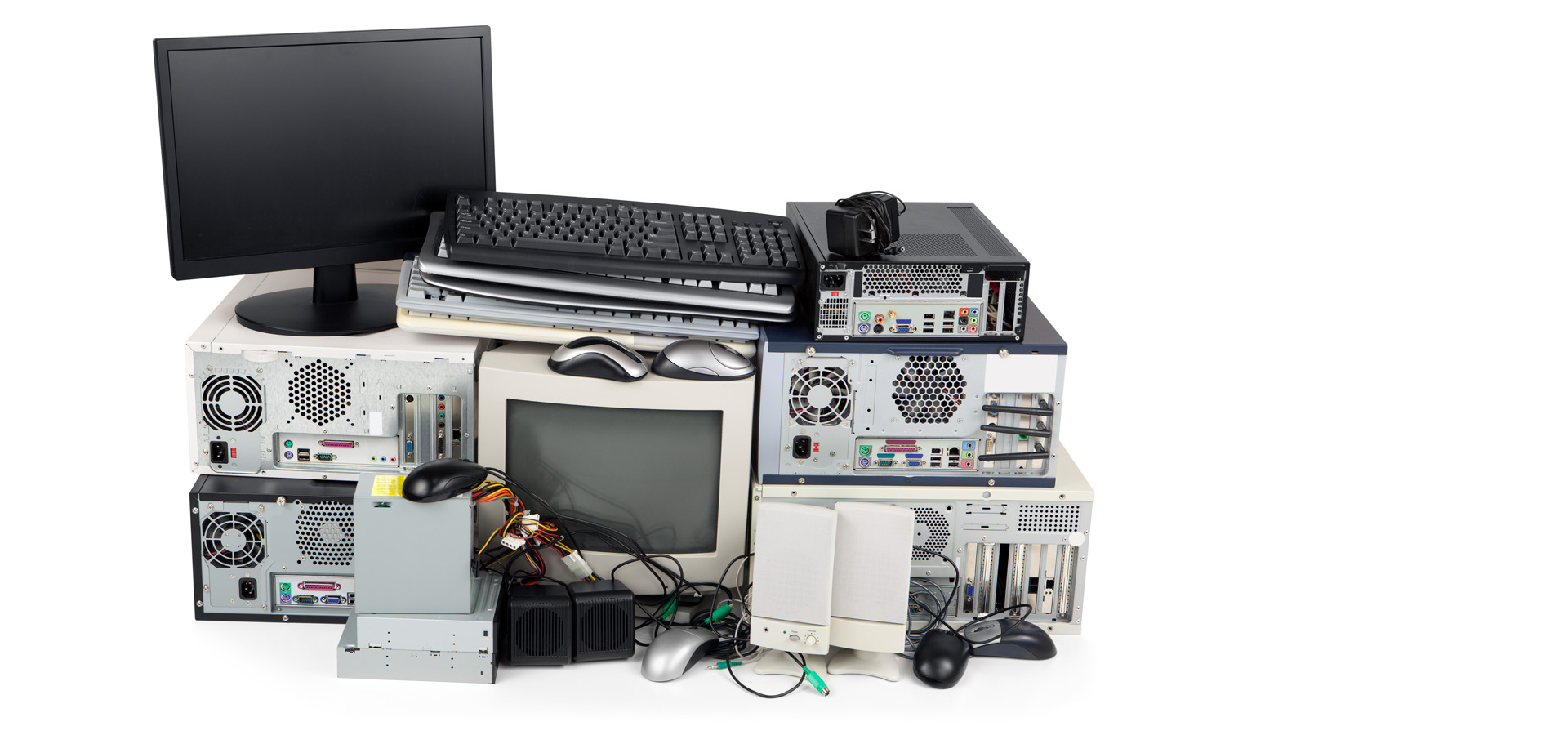 A pile of e-waste, old weee equipment pc computers, servers, screens, keyboards, mice speakers for secure disposal and recycling